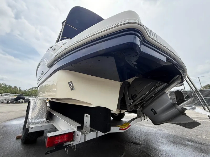 Slide: The Image of 2015 Chaparral Sunesta 224 boat on trailer, rear view, showcasing hull and outdrive. - 9
