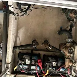 Slide: The Image of Engine compartment of 2006 Luhrs 28 Open boat showing batteries and plumbing. - 15