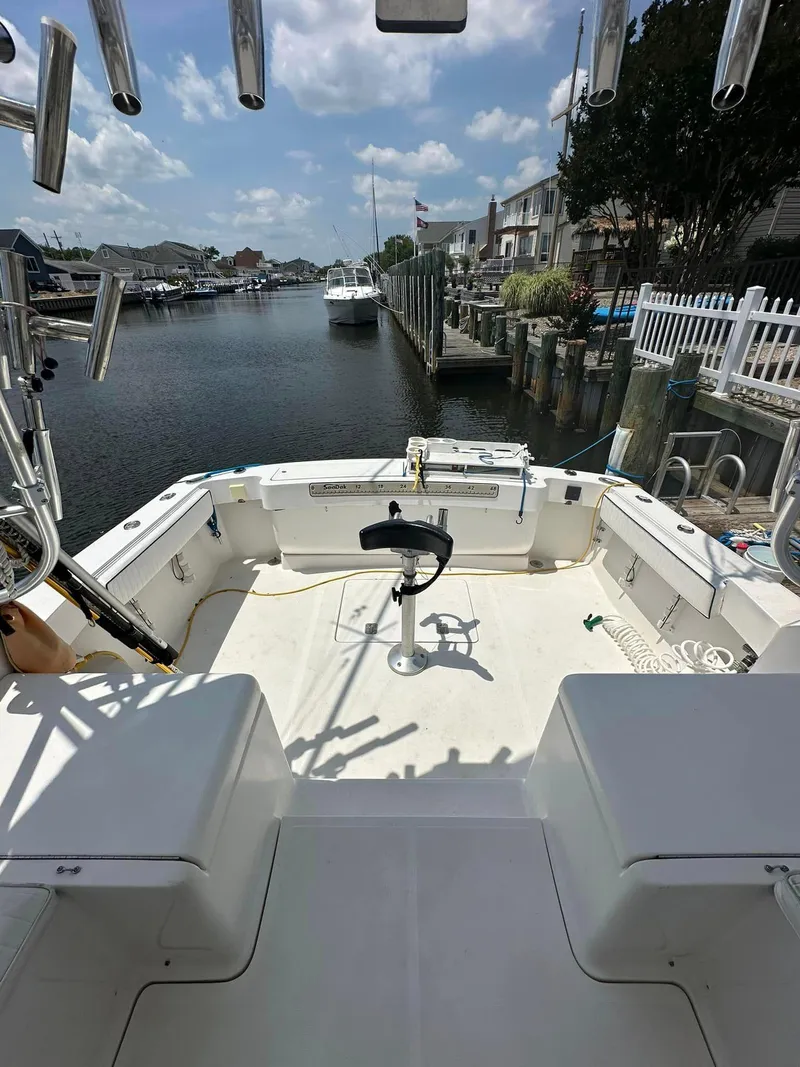 Slide: The Image of 2006 Luhrs 28 Open boat with spacious deck, docked in a serene marina. - 2