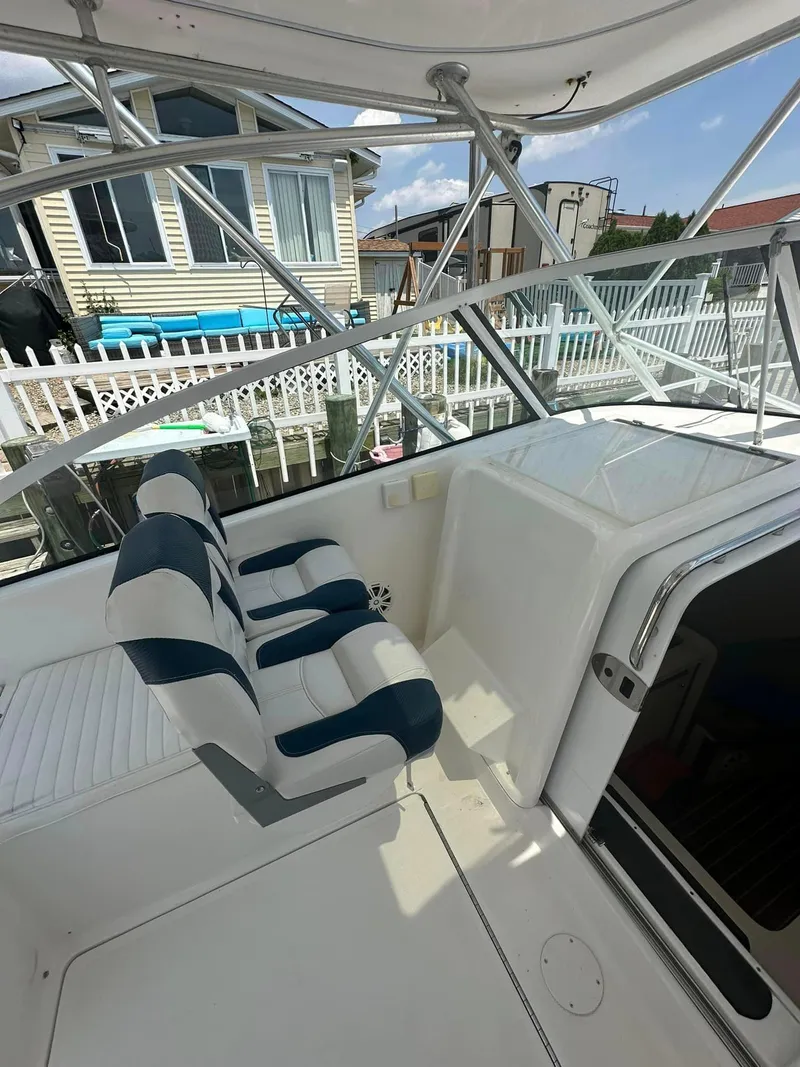 Slide: The Image of 2006 Luhrs 28 Open boat interior with striped seating and marina view. - 4