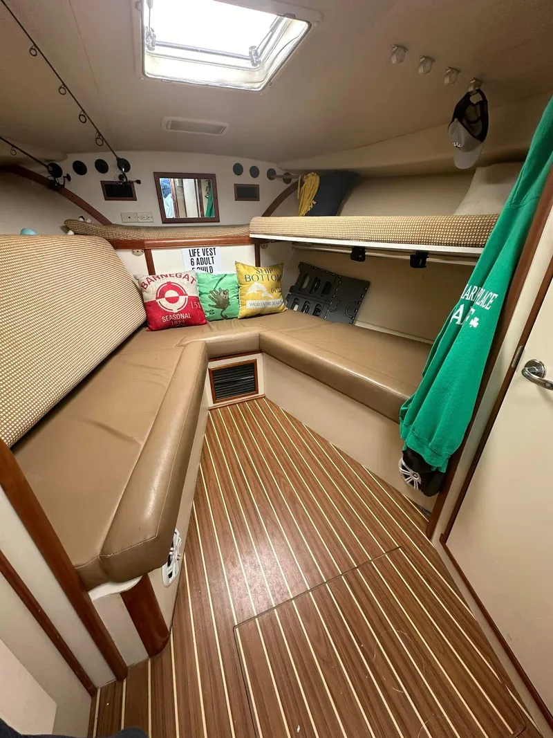 Slide: The Image of 2006 Luhrs 28 Open cabin interior with seating, cushions, and wood flooring. - 9