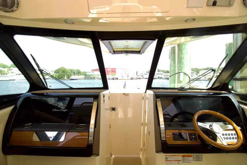 Slide: The Image of 2025 Chris-Craft Calypso 32 helm with modern controls and waterfront view. - 16