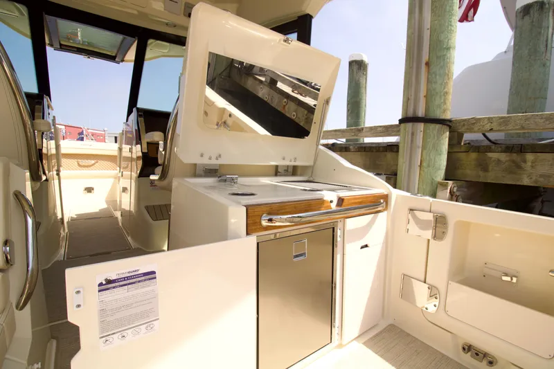 Slide: The Image of 2025 Chris-Craft Calypso 32 boat interior with kitchenette and seating area. - 19