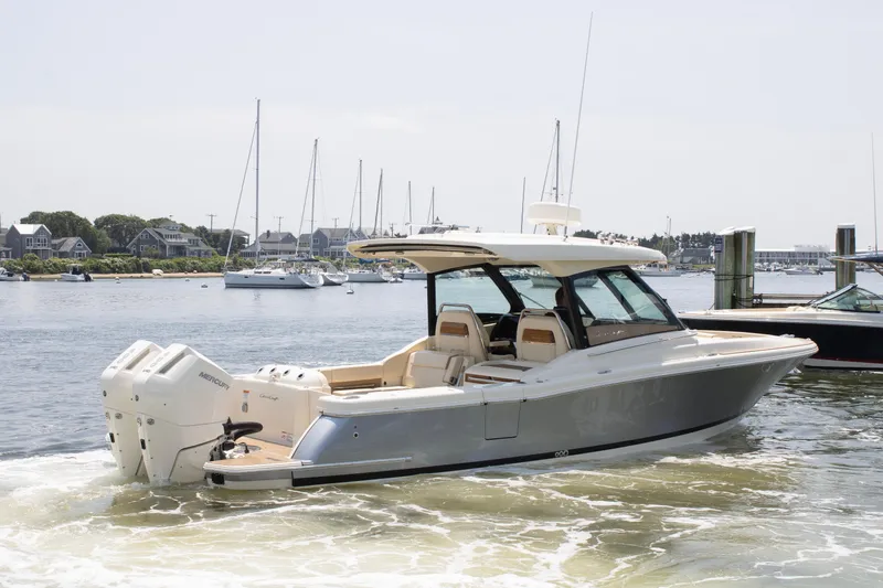 Slide: The Image of 2025 Chris-Craft Calypso 32 boat cruising in a marina with scenic background. - 2