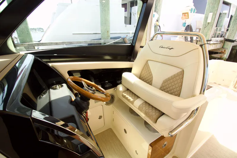Slide: The Image of 2025 Chris-Craft Calypso 32 helm with luxurious seating and wooden steering wheel. - 23