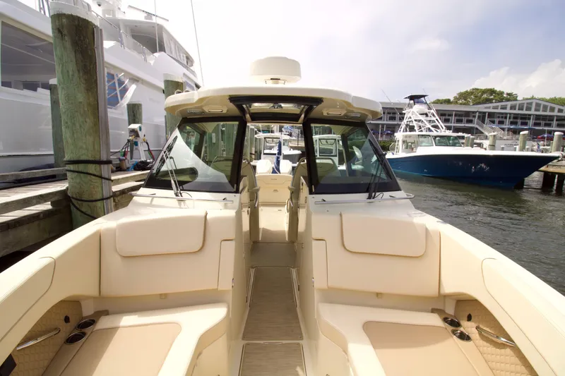 Slide: The Image of 2025 Chris-Craft Calypso 32 boat docked at marina, showcasing spacious seating and sleek design. - 25
