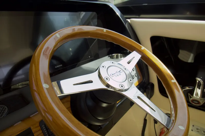 Slide: The Image of 2025 Chris-Craft Calypso 32 steering wheel, featuring elegant wood and chrome design. - 33