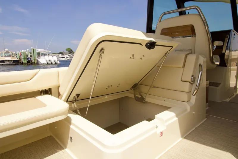 Slide: The Image of 2025 Chris-Craft Calypso 32 boat interior with open storage compartment, docked at marina. - 41