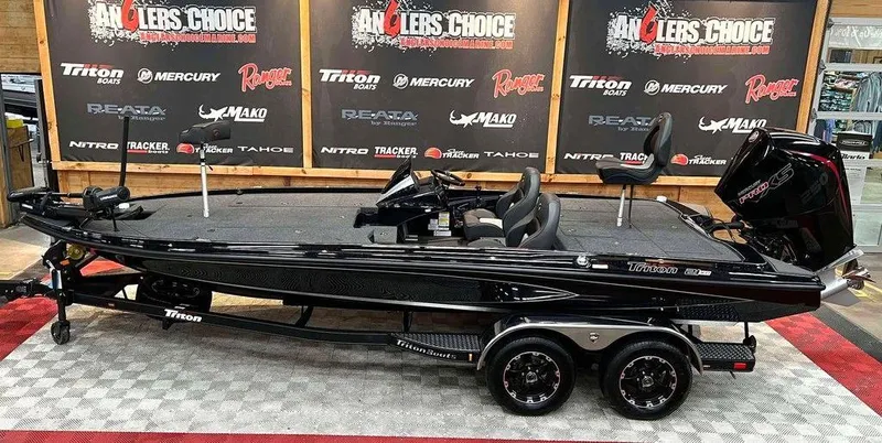 The Image of 2025 Triton 21XP boat displayed indoors, featuring sleek black design and dual-axle trailer. - 1
