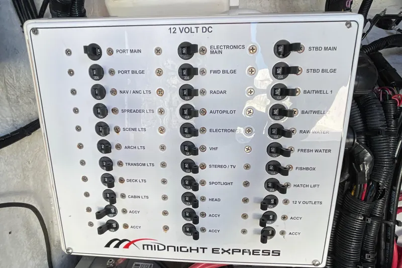 Slide: The Image of Control panel of a 2009 Midnight Express 34' Open boat, featuring various switches and labels. - 27