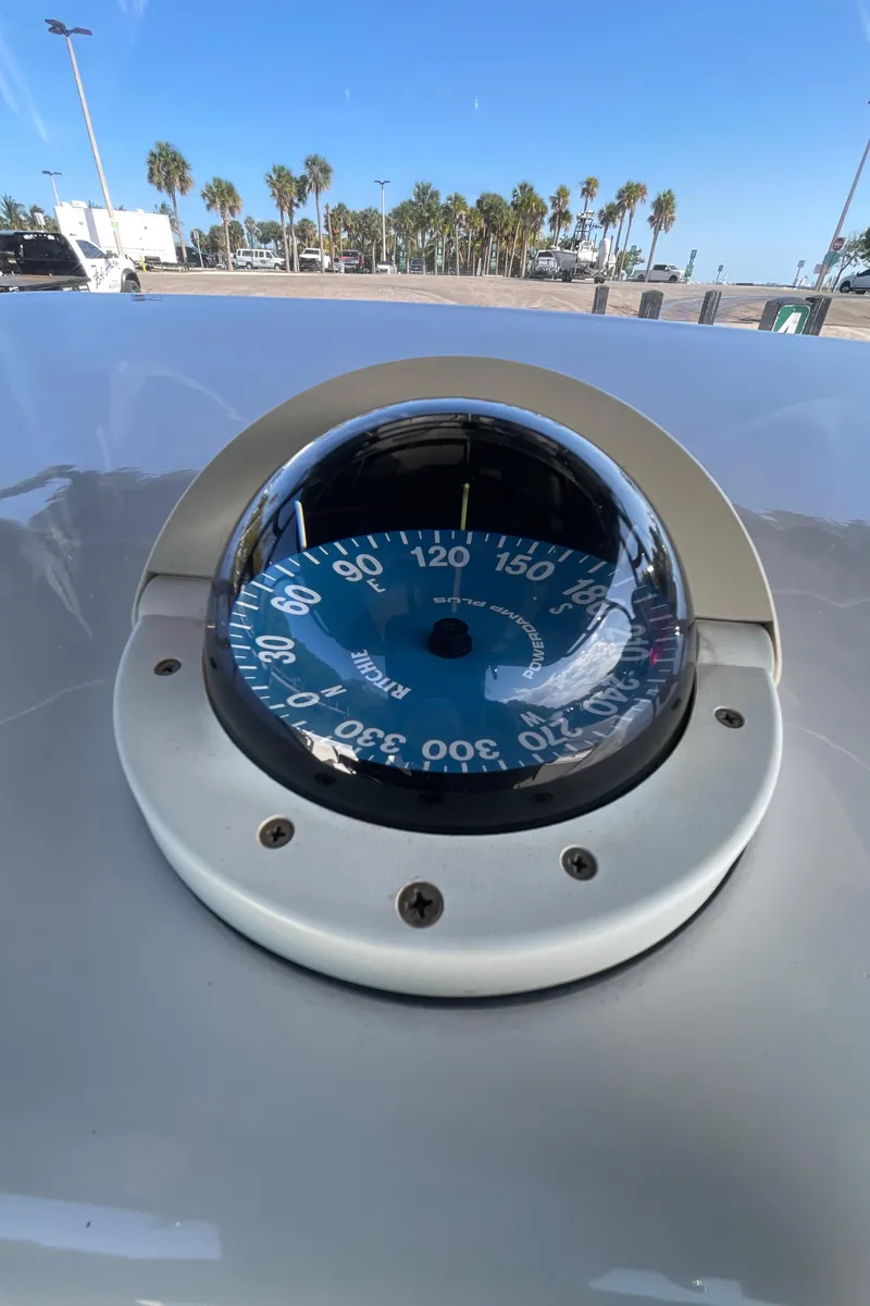 Slide: The Image of Compass on 2009 Midnight Express 34' Open boat, with palm trees in the background. - 30