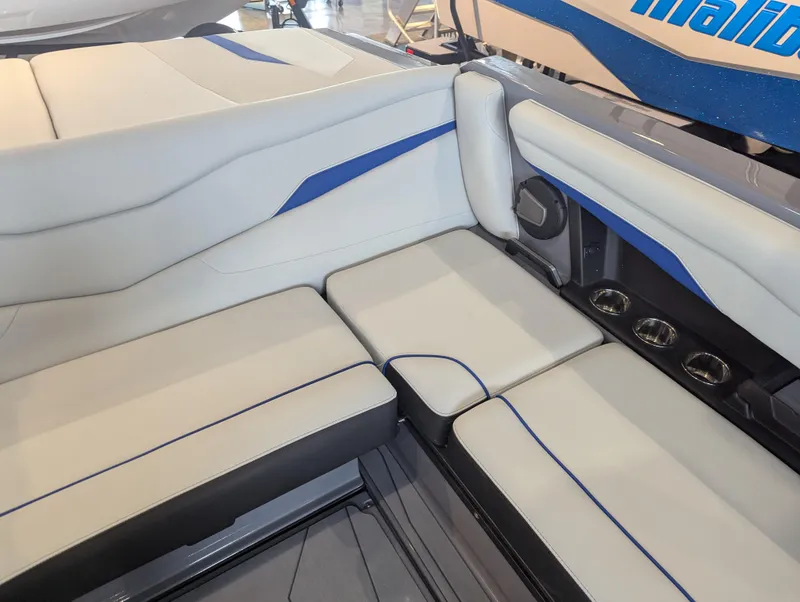 Slide: The Image of 2025 Axis T220 boat interior with white and blue seating and cup holders. - 11