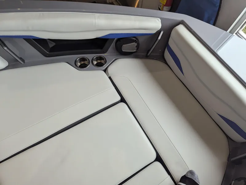 Slide: The Image of Interior seating of 2025 Axis T220 boat with white upholstery and cup holders. - 14