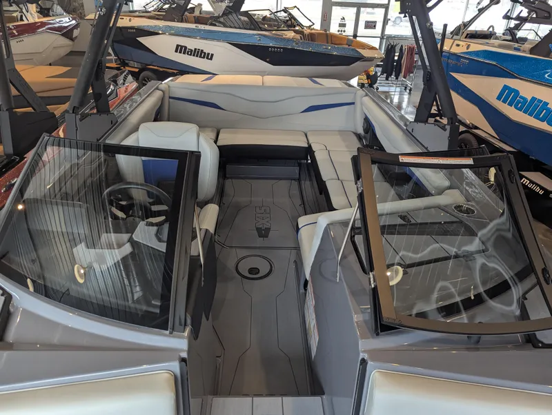 Slide: The Image of 2025 Axis T220 boat interior with seating and steering wheel, displayed in showroom. - 17
