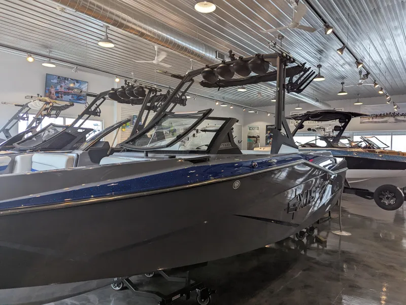 Slide: The Image of 2025 Axis T220 boat in showroom, sleek design, modern features, metallic finish. - 3