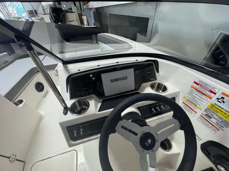 Slide: The Image of 2025 Bayliner D22 boat dashboard with Simrad display and steering wheel. - 4