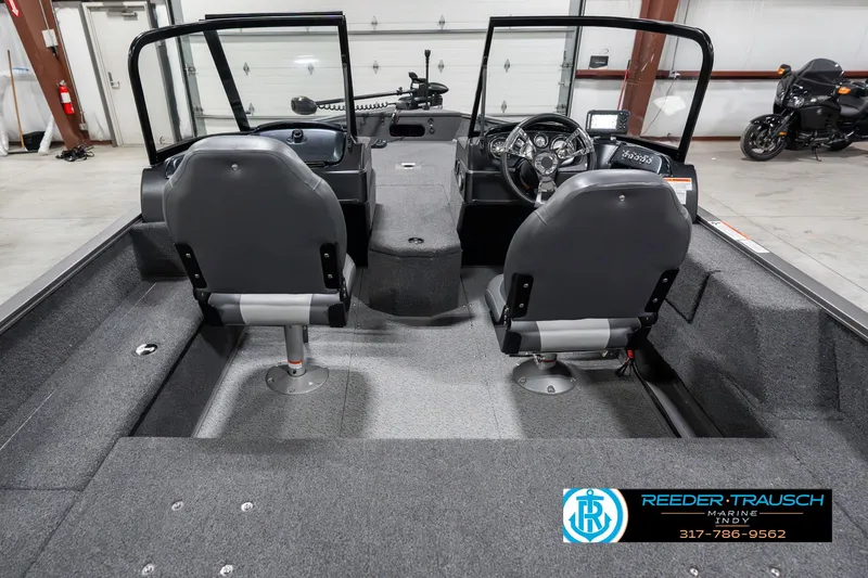 Slide: The Image of 2023 Lowe FM 1775 boat interior with dual seats and steering console in a garage. - 14