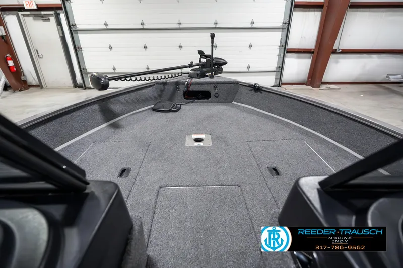 Slide: The Image of 2023 Lowe FM 1775 boat interior with trolling motor in a garage setting. - 16