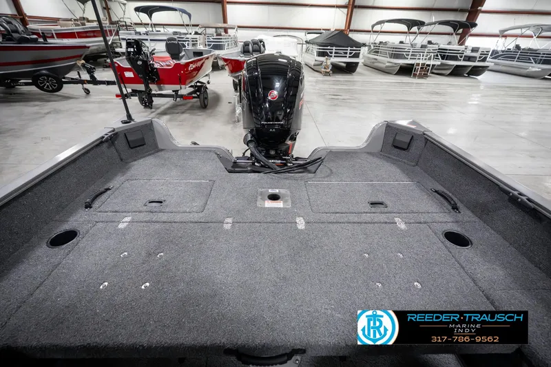 Slide: The Image of 2023 Lowe FM 1775 boat interior with motor, displayed in a showroom. - 19