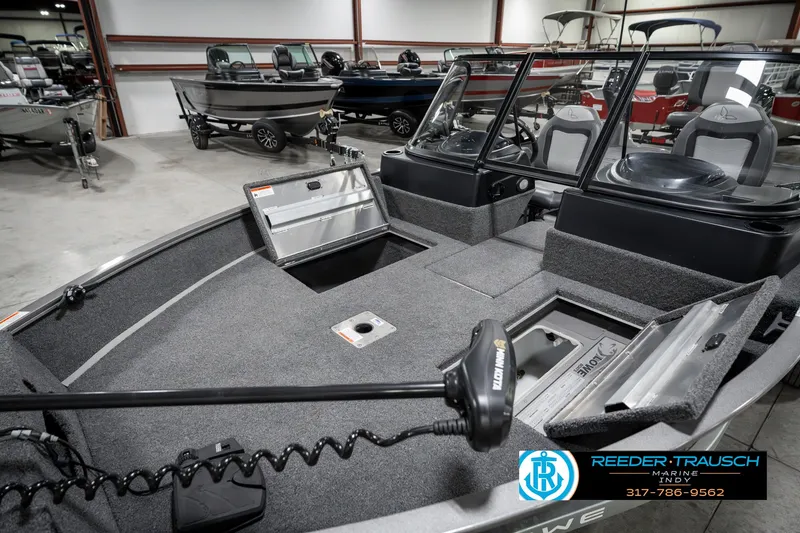 Slide: The Image of 2023 Lowe FM 1775 boat interior in showroom, featuring storage compartments and seating. - 22