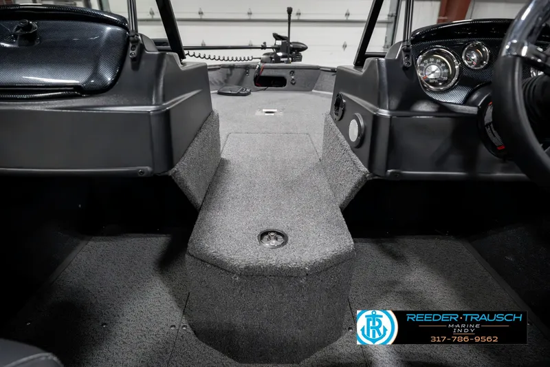 Slide: The Image of 2023 Lowe FM 1775 boat interior with carpeted flooring and dashboard controls. - 23