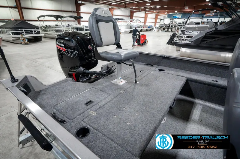 Slide: The Image of 2023 Lowe FM 1775 boat interior with seating and motor in showroom. - 29