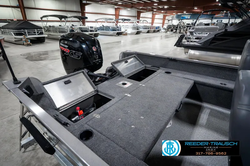 Slide: The Image of 2023 Lowe FM 1775 boat interior with storage compartments and motor in showroom. - 33