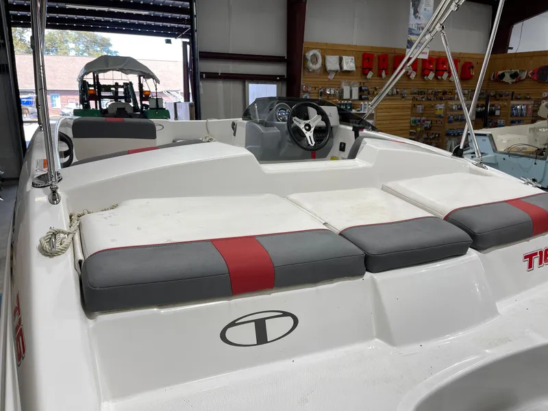 Slide: The Image of 2020 Tahoe T16 boat interior with cushioned seating and steering wheel in showroom. - 12