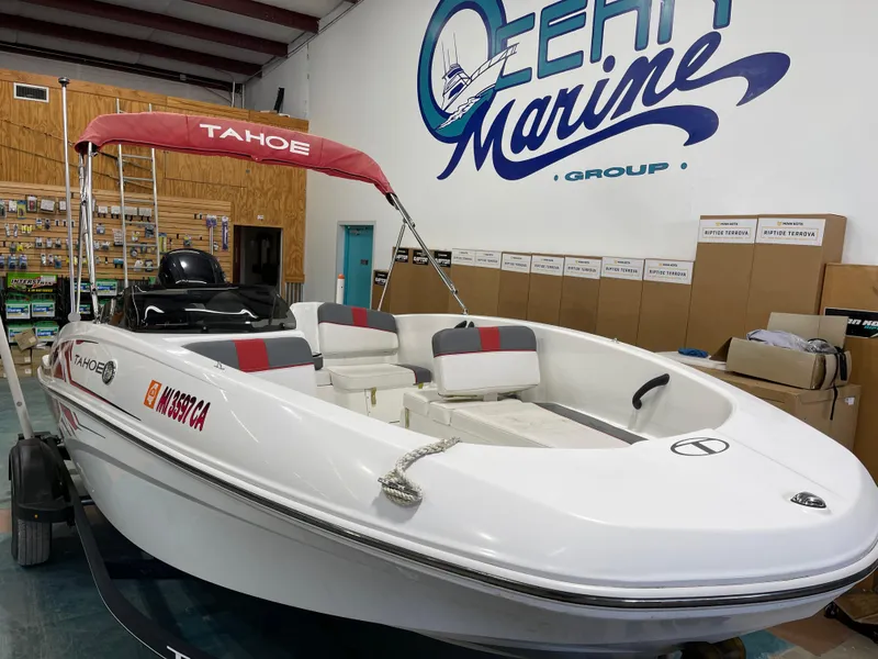 Slide: The Image of 2020 Tahoe T16 boat in showroom, featuring red canopy and white seating. - 6