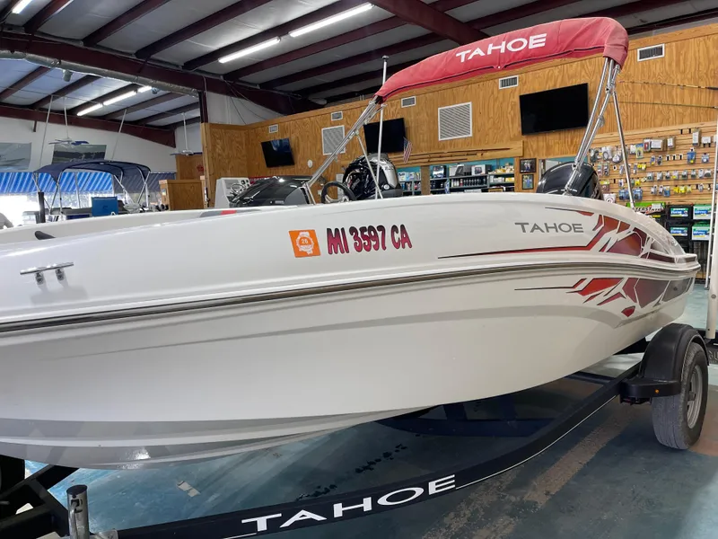 Slide: The Image of 2020 Tahoe T16 boat in showroom, white with red accents, on trailer. - 8
