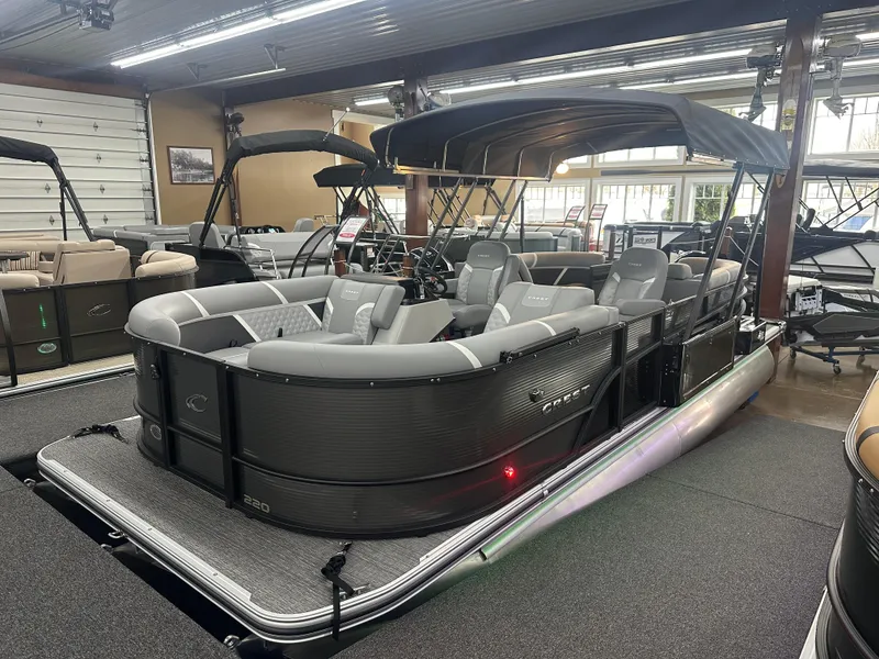 The Image of 2025 Crest Classic 220 pontoon boat with sleek design in showroom setting. - 1