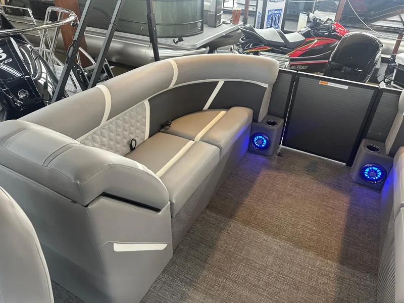Slide: The Image of 2025 Crest Classic 220 boat interior with gray seating and blue LED speakers. - 12