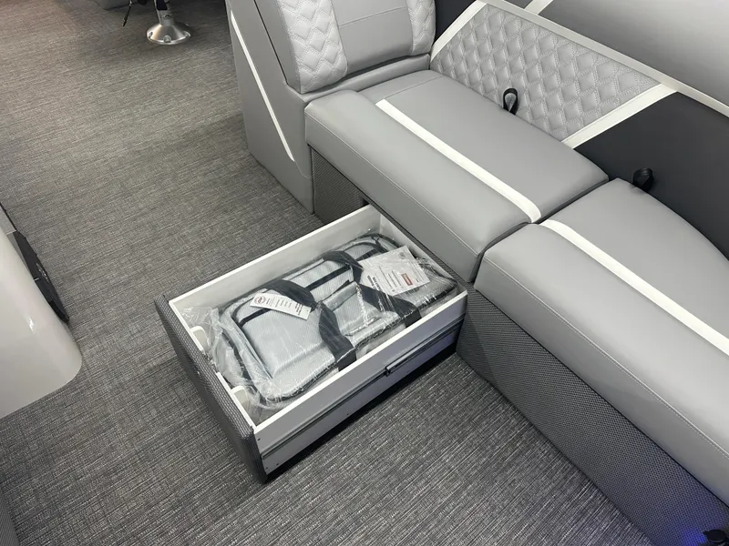 Slide: The Image of 2025 Crest Classic 220 interior with open storage drawer under gray seating. - 5