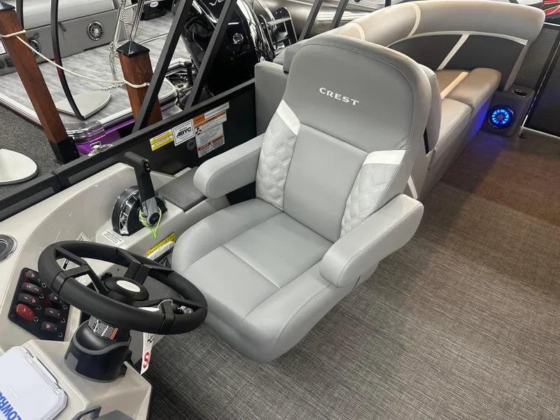 Slide: The Image of 2025 Crest Classic 220 boat interior with gray captain's chair and steering wheel. - 9