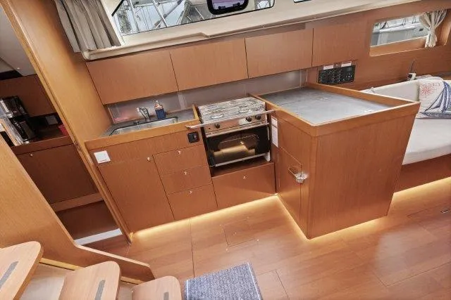 Slide: The Image of 2018 Beneteau Oceanis 41.1 yacht interior kitchen with wood cabinetry and modern appliances. - 10