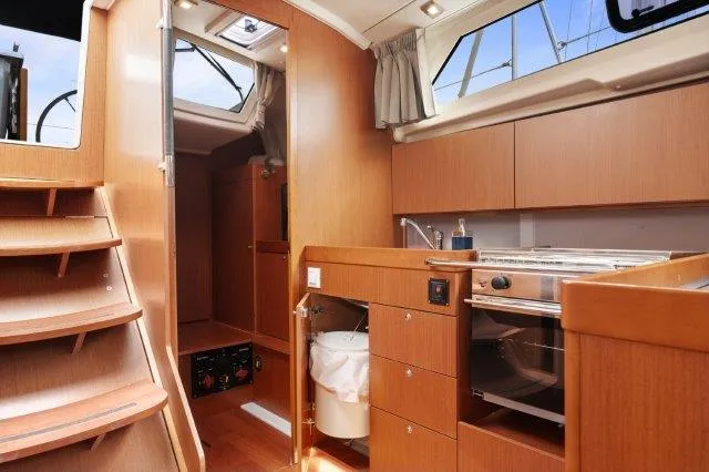 Slide: The Image of Interior of 2018 Beneteau Oceanis 41.1 yacht with modern kitchen and wooden cabinetry. - 15