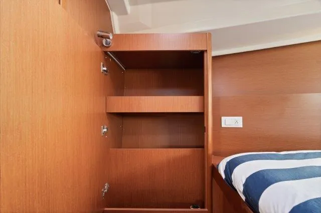 Slide: The Image of Interior of 2018 Beneteau Oceanis 41.1 yacht showing wooden storage shelves and bed. - 19
