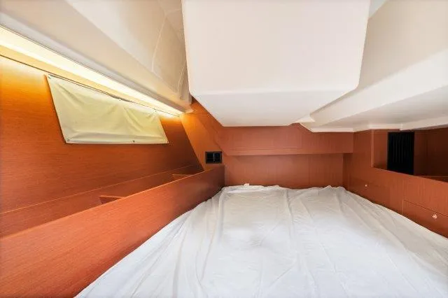 Slide: The Image of Interior cabin of 2018 Beneteau Oceanis 41.1 yacht, featuring wooden finish and white bedding. - 22