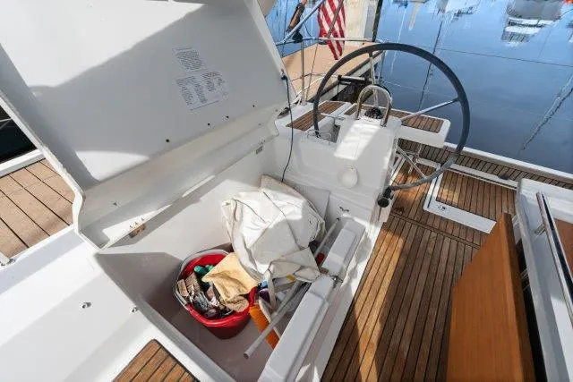 Slide: The Image of 2018 Beneteau Oceanis 41.1 cockpit with open storage, steering wheel, and wooden deck. - 36