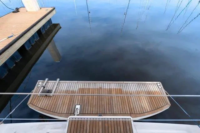 Slide: The Image of Beneteau Oceanis 41.1 (2018) yacht stern view at dock, calm water reflection. - 49