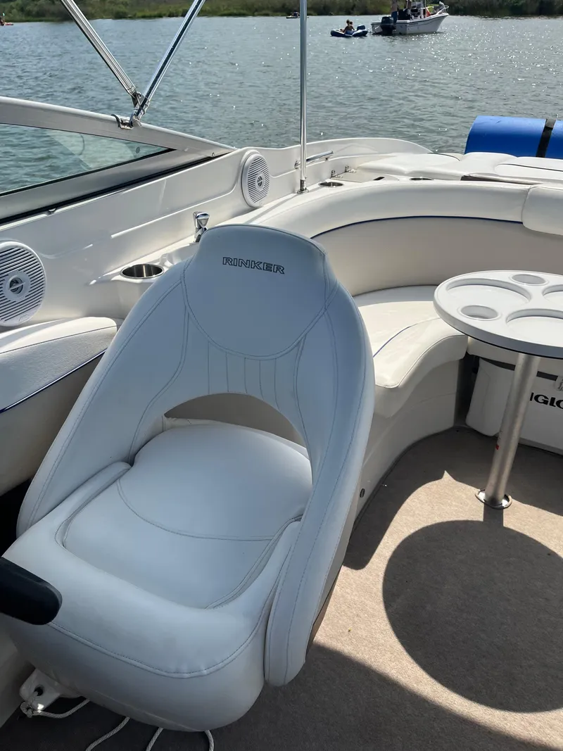 Slide: The Image of 2008 Rinker 246 Captiva Bowrider interior with white seating and table on a sunny day. - 10