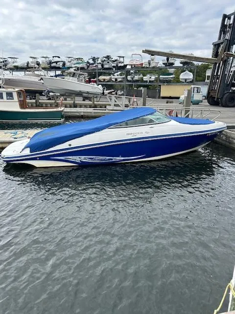 Slide: The Image of 2008 Rinker 246 Captiva Bowrider with blue cover docked at marina. - 13