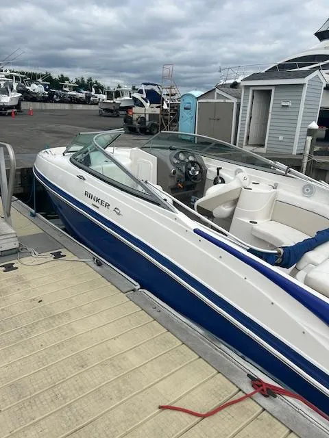 Slide: The Image of 2008 Rinker 246 Captiva Bowrider docked at marina, blue and white design. - 14