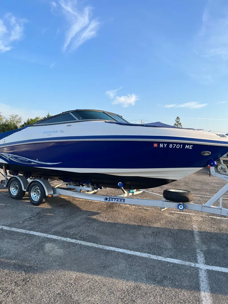 Slide: The Image of 2008 Rinker 246 Captiva Bowrider on trailer, blue and white design, parked outdoors. - 5