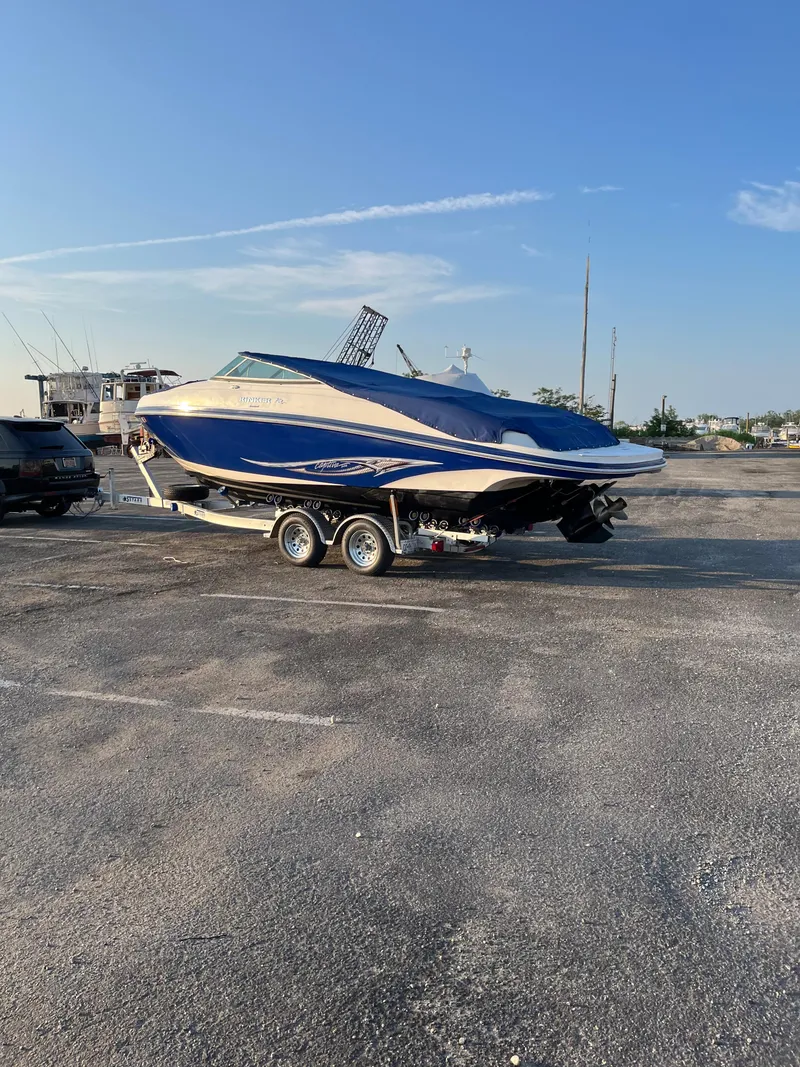 Slide: The Image of 2008 Rinker 246 Captiva Bowrider on trailer in parking lot, blue and white design. - 6