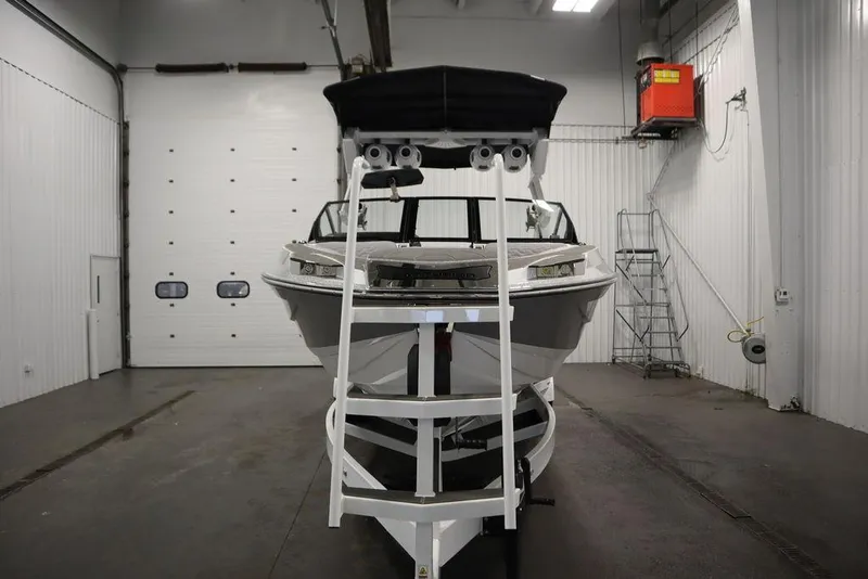 Slide: The Image of 2025 Centurion Ri245 boat in a garage, front view with trailer. - 3
