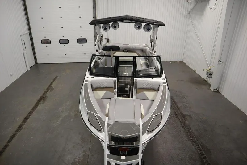Slide: The Image of 2025 Centurion Ri245 boat in a garage, showcasing sleek design and spacious interior. - 9
