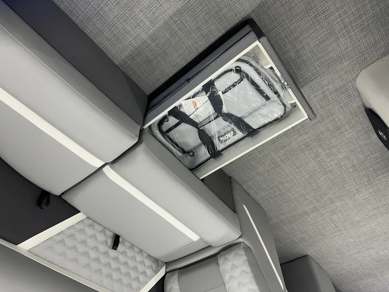 Slide: The Image of 2025 Crest Classic 220 boat interior with storage compartment and gray seating. - 3