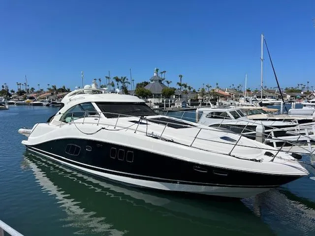 Slide: The Image of 2008 Sea Ray 55 Sundancer yacht docked in a marina under clear blue skies. - 0