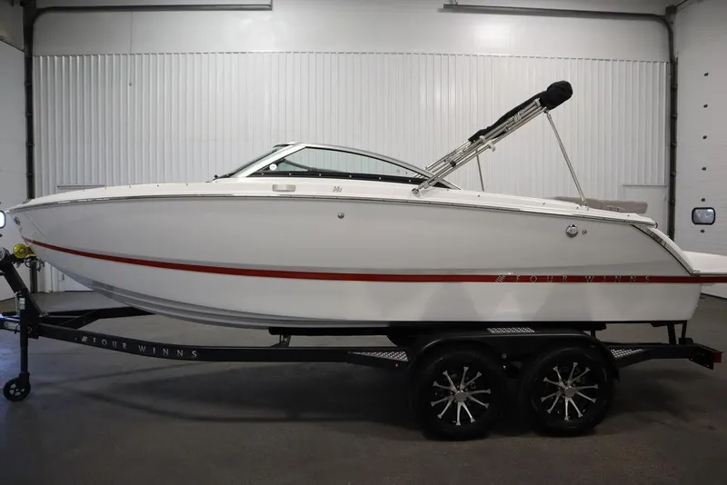 Slide: The Image of 2025 Four Winns H1 boat on trailer in indoor setting. - 1